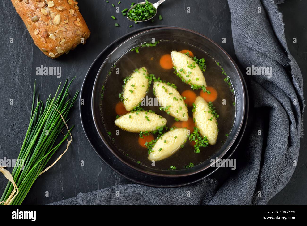 Piatto bavarese, svevo e austriaco - gnocchi di semola in brodo vegetale, servito con un rotolo integrale Foto Stock