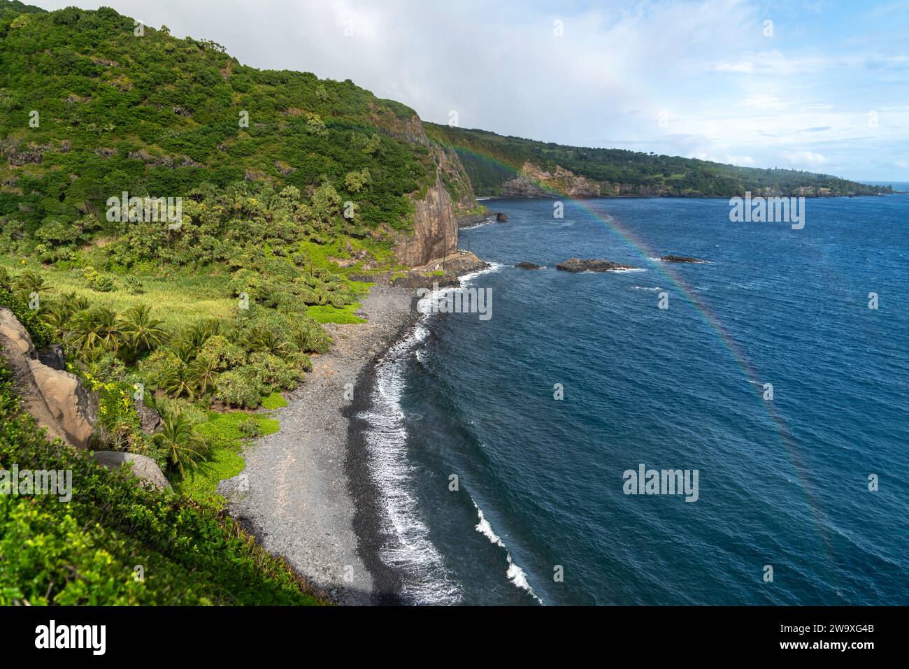 Questa appartata spiaggia di sabbia nera, incorniciata da una lussureggiante vegetazione tropicale e rocce laviche, è un luogo tranquillo lungo la costa meridionale di Maui vicino all'autostrada Piilani. Foto Stock
