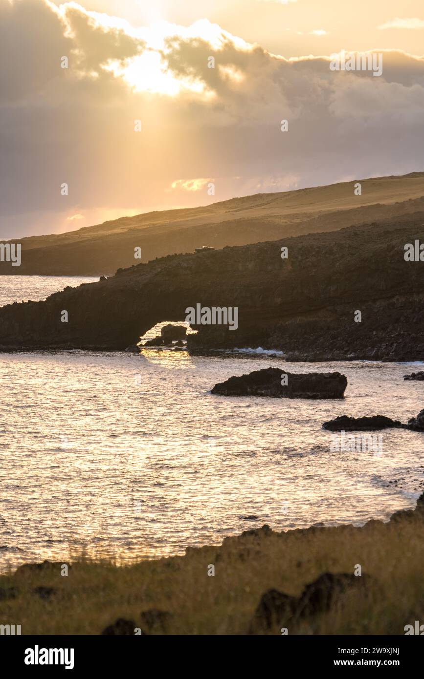 Mentre il sole tramonta lungo la Piilani Highway, una barca solitaria si staglia contro le scintillanti acque della costa meridionale di Maui, catturando l'essenza di Foto Stock
