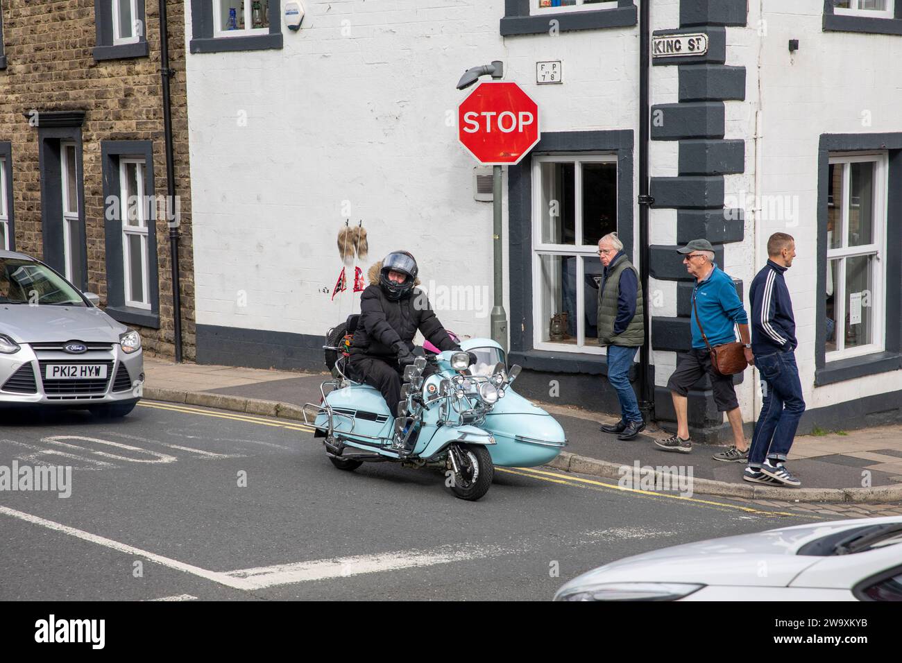 Uomo e moglie in scooter con sidecar nel centro di Clitheroe, Lancashire, durante il rally di scooter del 2023 nel centro città, Inghilterra, Regno Unito Foto Stock