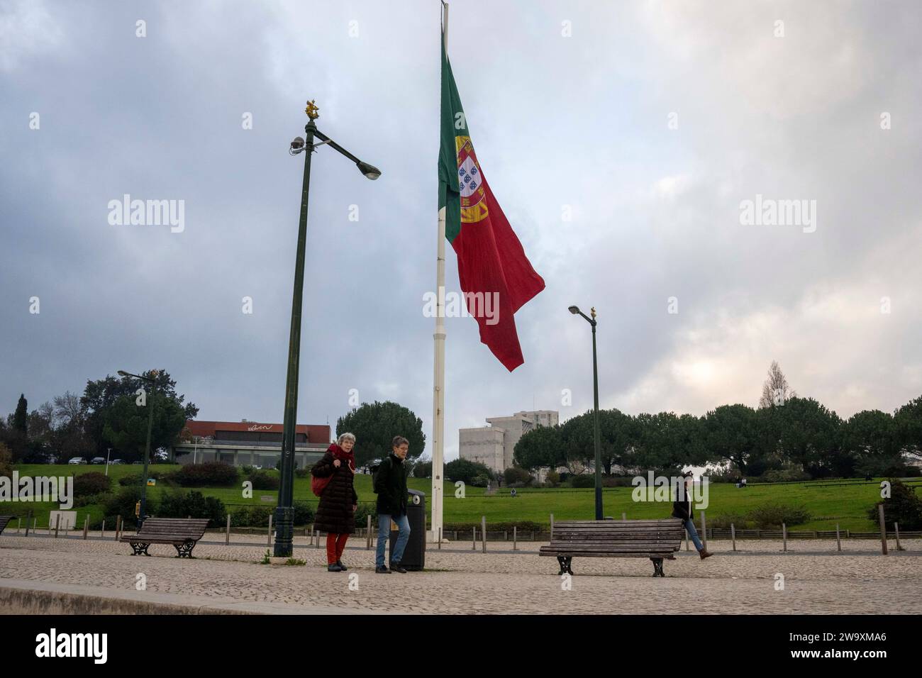 Lisbona, Portogallo. 30 dicembre 2023. La gente cammina vicino a una bandiera del Portogallo situata nelle vicinanze del parco Edoardo VII a Lisbona. Credito: SOPA Images Limited/Alamy Live News Foto Stock