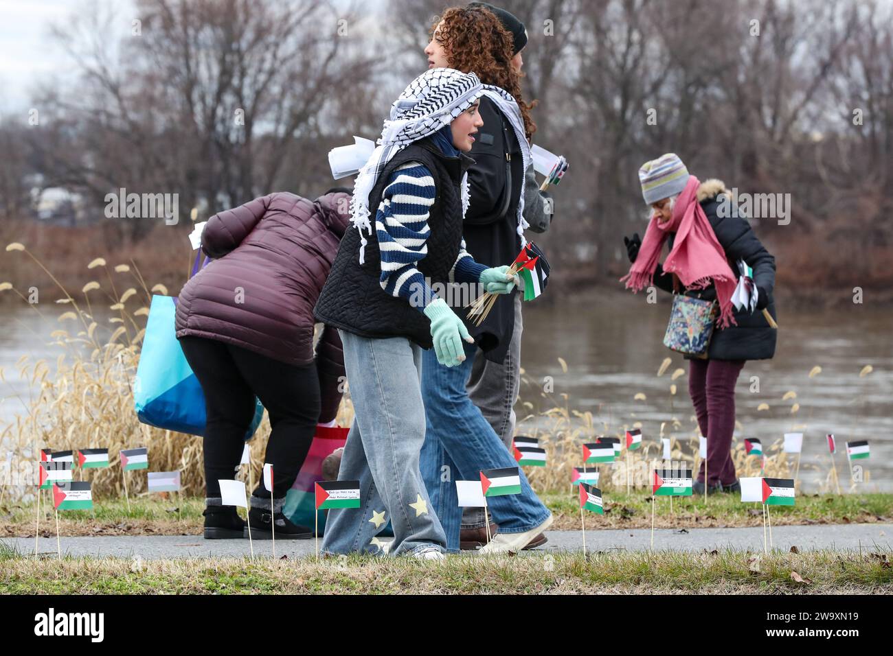 Harrisburg, Stati Uniti. 30 dicembre 2023. La gente pone piccole bandiere palestinesi nel terreno lungo Front Street a Harrisburg Pa. Il 30 dicembre 2023. I manifestanti hanno piazzato più di 20.000 bandiere, una per ogni persona uccisa a Gaza dall'inizio della guerra Israele-Hamas, lungo la strada vicino alla residenza del governatore della Pennsylvania. (Foto di Paul Weaver/Sipa USA) credito: SIPA USA/Alamy Live News Foto Stock