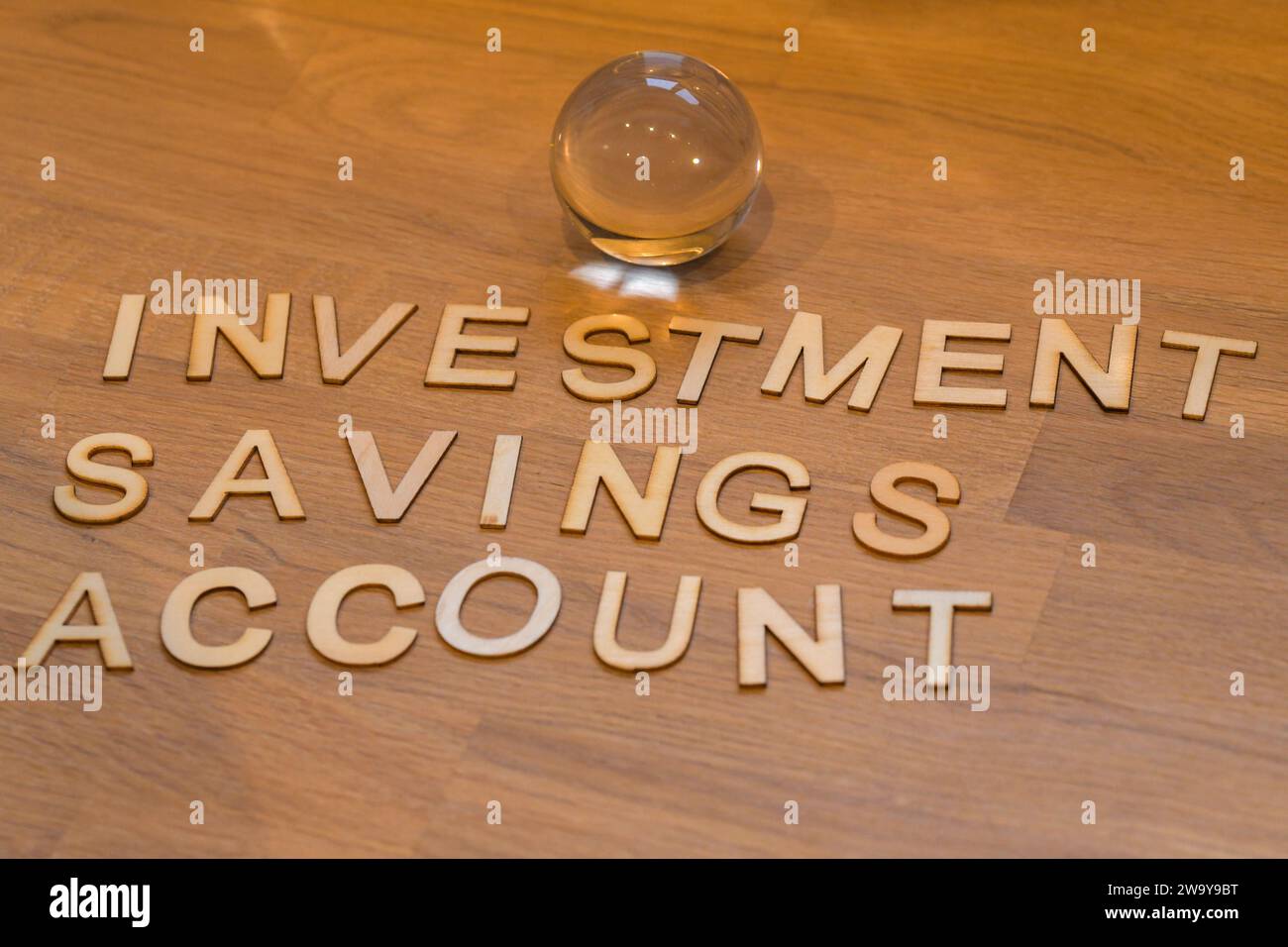ISA, conto di risparmio sugli investimenti in lettere di legno su una superficie di legno con una sfera di cristallo di vetro. il futuro del risparmio Foto Stock