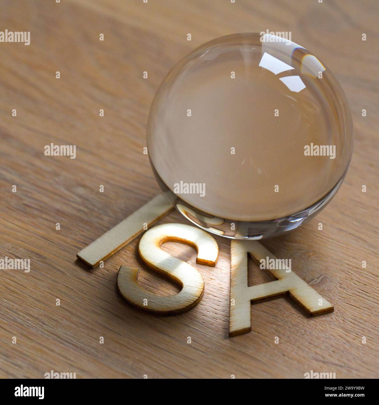 ISA, conto di risparmio individuale in lettere di legno su una superficie di legno con una sfera di cristallo di vetro. il futuro del risparmio Foto Stock