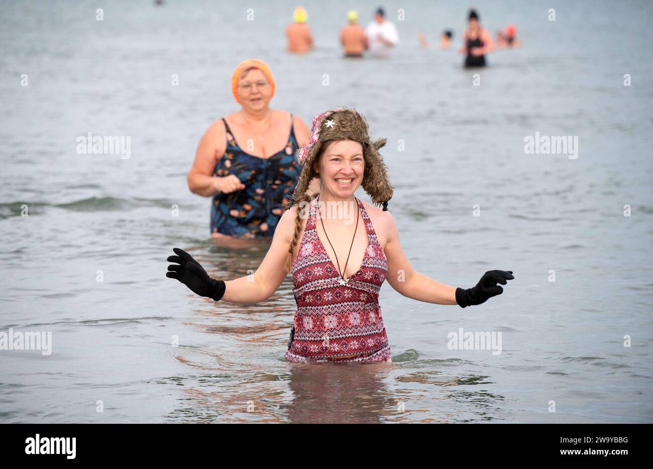 Schwimmer der Rostocker Seehunde beim Sylvesterbad in der knapp 5 Grad kalten Ostsee. Der Winterschwimm-Verein Rostocker Seehunde lädt regelmäßig mit mehreren Veranstaltungen zum Winterbaden von Ende September bis Ende April, auch zu Weihnachten, Silvester und Neujahr. Rostock Waenemünde *** nuotatori delle foche di Rostock alla vigilia di Capodanno nuotano nel Mar Baltico, poco meno di 5 gradi, il Rostock Seals Winter Swimming Club organizza regolarmente diversi eventi invernali di nuoto dalla fine di settembre alla fine di aprile, tra cui a Natale, Capodanno e Capodanno a Rostock Foto Stock