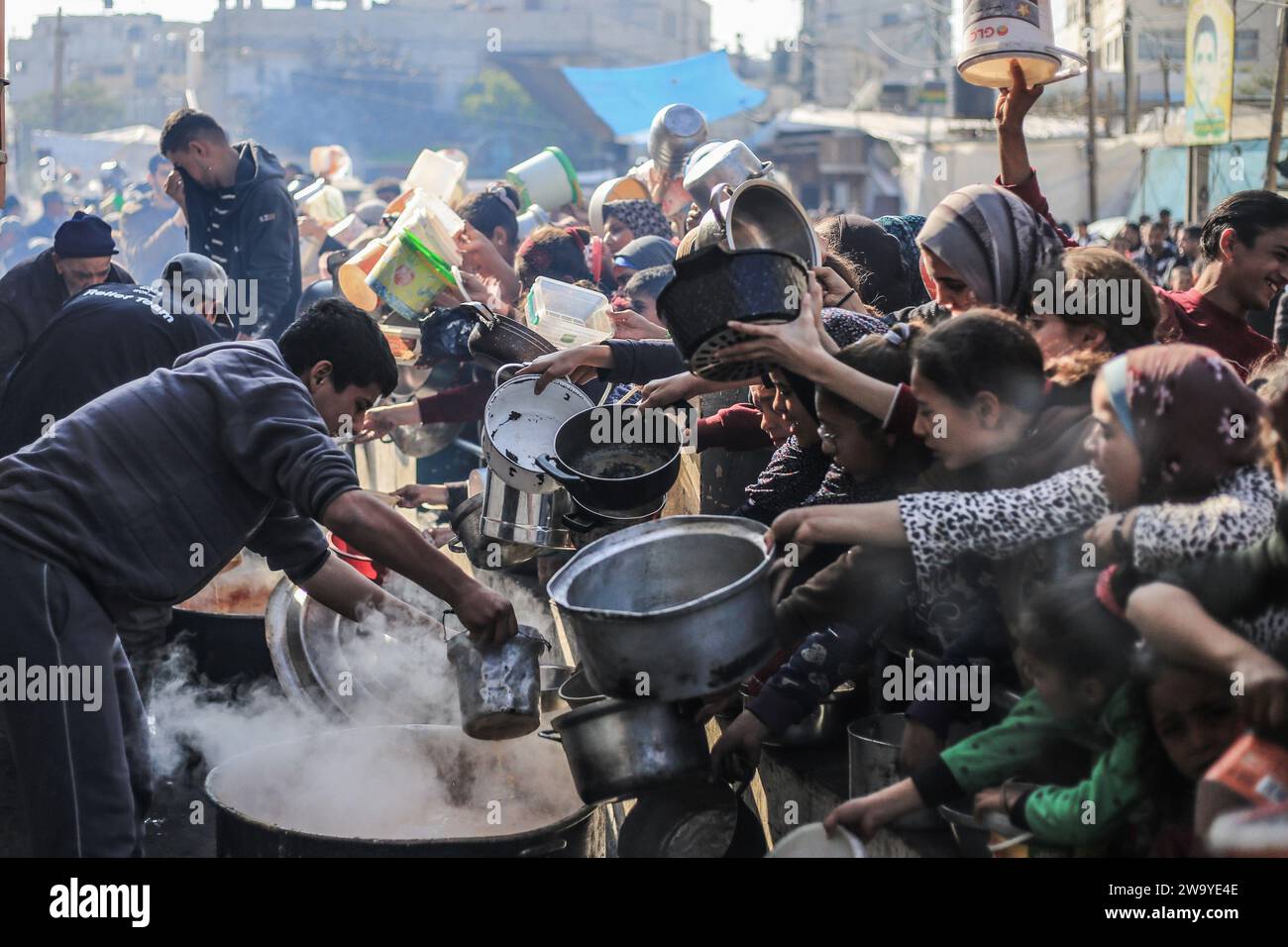 Rafah, territori palestinesi. 31 dicembre 2023. I palestinesi ricevono cibo preparato in una cucina di beneficenza in mezzo alla mancanza di provviste di cibo mentre continuano i combattimenti tra Israele e Hamas. Credito: Mohammed Talatene/dpa/Alamy Live News Foto Stock