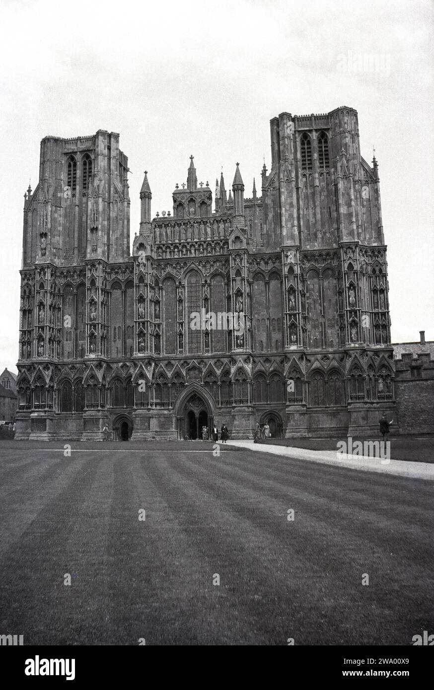 1950, storico, esterno della cattedrale di Wells, Somerset, Inghilterra, Regno Unito. Costruita in stile gotico inglese, era originariamente una cattedrale cattolica romana, ma divenne una cattedrale anglicana quando Enrico VIII ordinò alla chiesa inglese di separarsi da Roma. Foto Stock