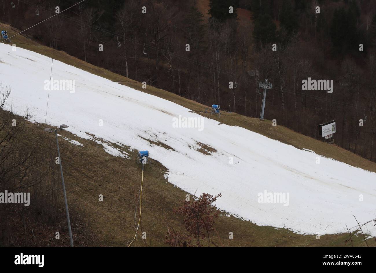 Garmisch-Partenkirchen, Deutschland 31. Dicembre 2023: 72.internationale Vierschanzentournee, Skispringen, Herren, Weltcup, Garmisch-Partenkirchen, Olympia Skistadion, 4hills, Olympiaschanze, Qualifikation Hier der Blick auf eine Skipiste mit wenig Schnee, ausserrum alles braun, Schneemangel, daneben ein Skilift der ausser Betrieb ist, sowie Schneekanonen, zu Warm, kein Skilaufen möglich, weisses Band *** Garmisch Partenkirchen, 31 dicembre 2023 72, torneo internazionale di salto a quattro colline, Germania coppa del mondo, Garmisch Partenkirchen, stadio Olimpico di sci, 4 colli, Olympic Hill, Qualif Foto Stock