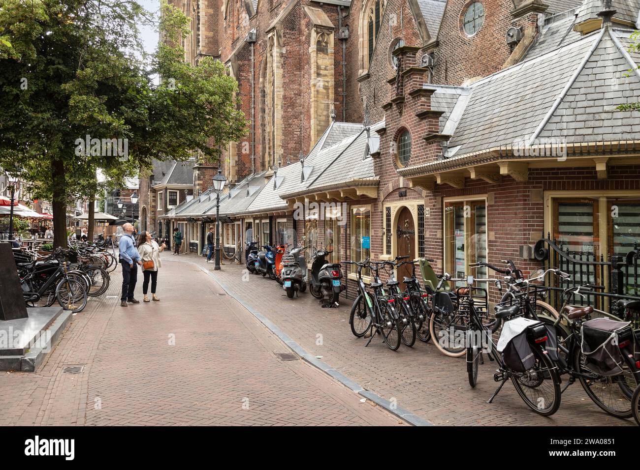 Strada di Haarlem con piccoli negozi costruiti contro la chiesa di San Bavone o Grote Kerk. Foto Stock