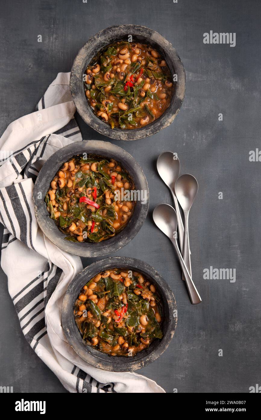 Tre ciotole di piselli vegani del sud degli Stati Uniti e di colletto verde in ciotole grigie scattate dall'alto con spazio per la copia Foto Stock