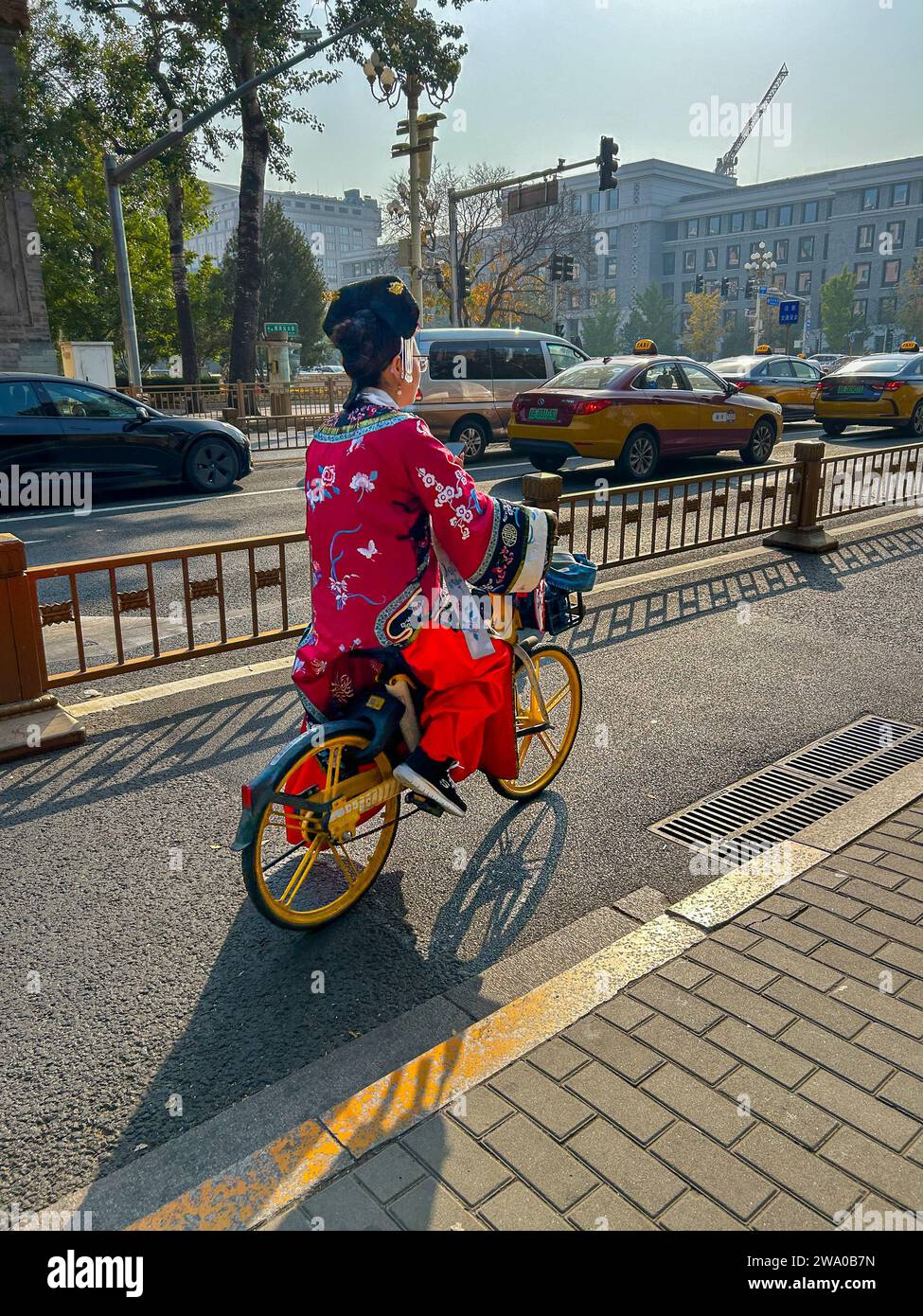Pechino, Cina, donna cinese in bicicletta in costume tradizionale, turisti, visite nella città Proibita, equitazione sulla scena di strada Foto Stock