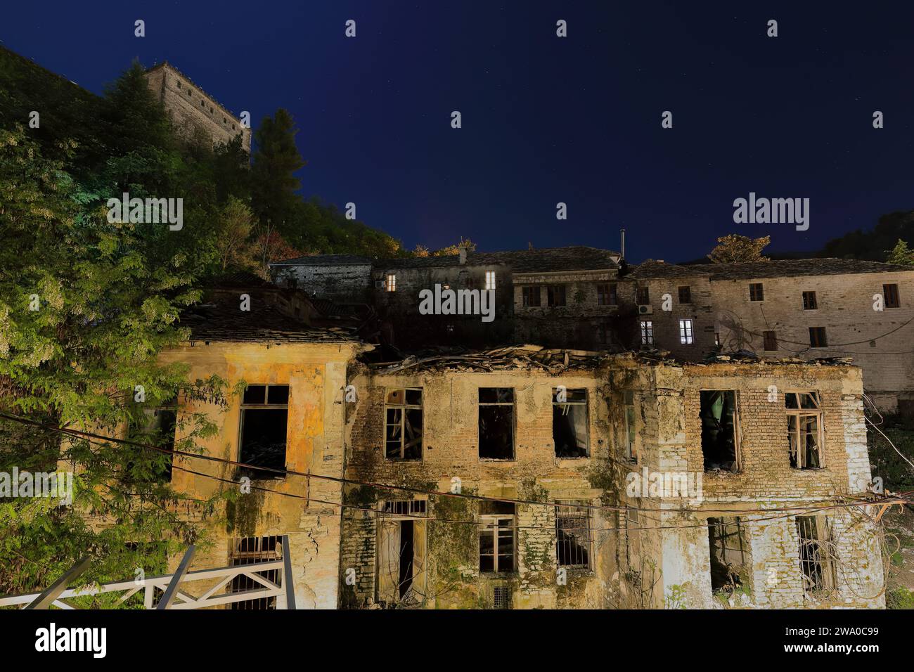 190 scena notturna di vecchie case in rovina ai piedi della collina della fortezza e retro di vecchie case a Rruga Gjin Bue Shpata. Gjirokaster-Albania. Foto Stock