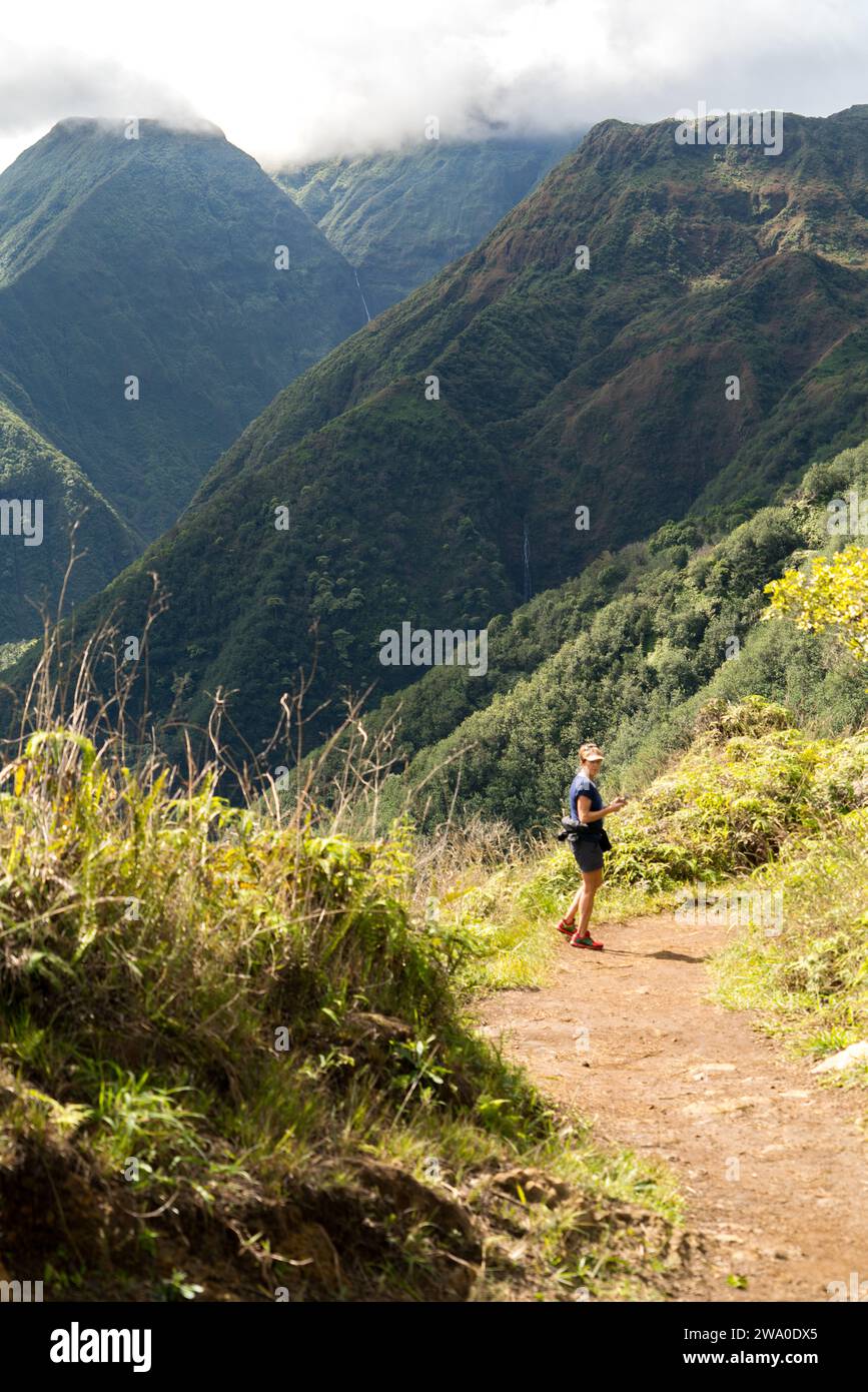 Un escursionista ti farà ammirare la vista della valle sul Waihe'e Ridge di Maui. Foto Stock