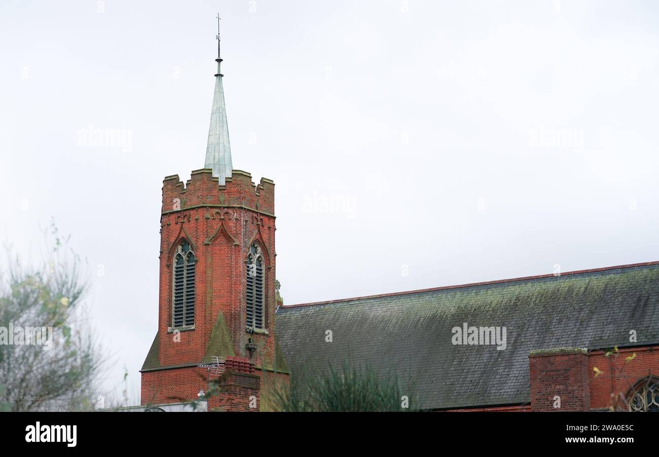 Un'intramontabile chiesa in mattoni rossi trafigge un cielo tempestoso Foto Stock