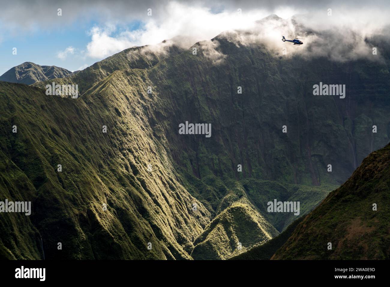 L'elicottero sorvola le verdeggianti montagne West Maui, viste dal Waihe'e Ridge. Foto Stock