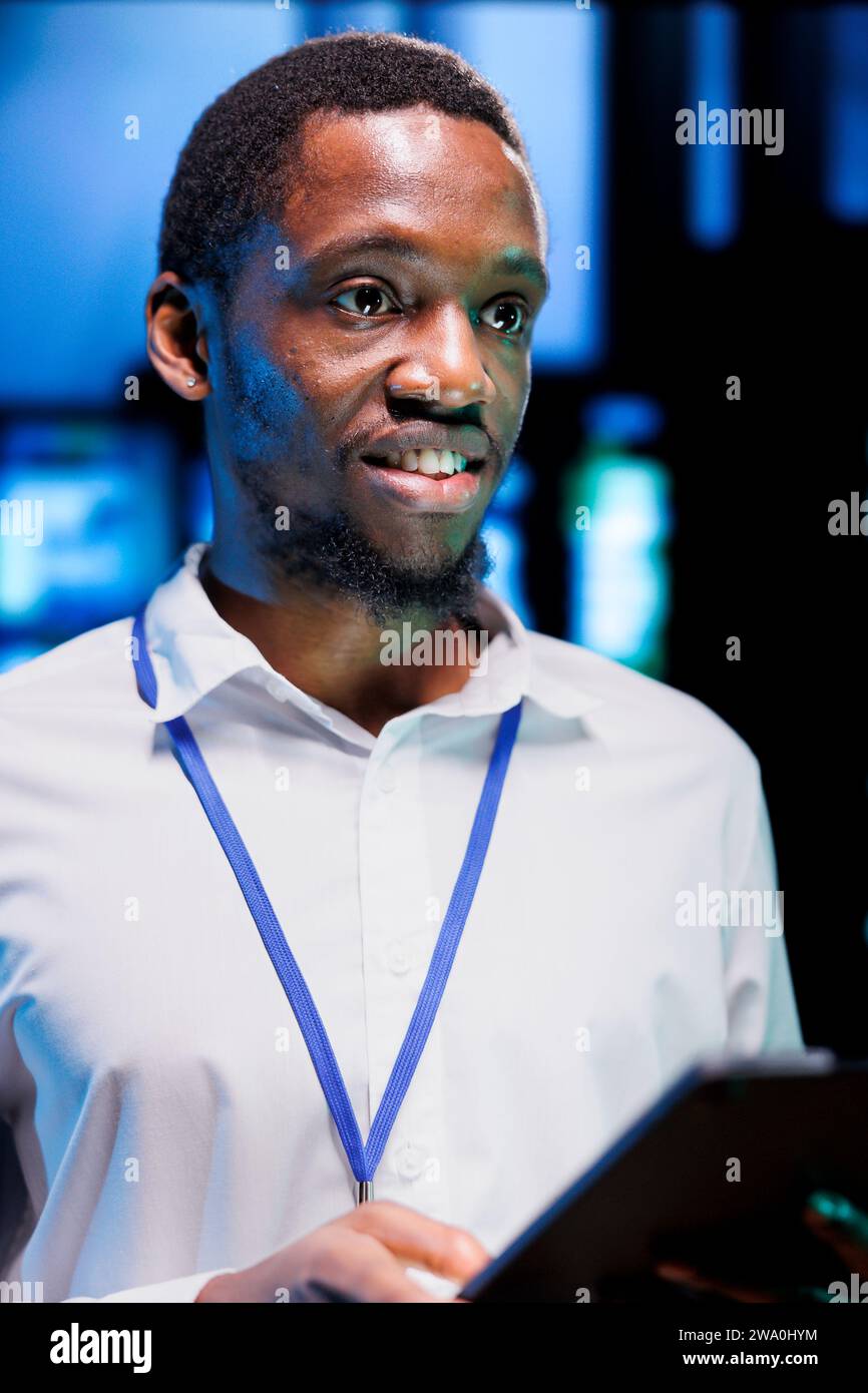 Manager che esegue i test diagnostici dei rack dei server e le utilità di controllo dei bug per determinare e riparare i problemi del software. Esperto che utilizza tablet per esaminare i sistemi critici, verificare la presenza di difetti, primo piano Foto Stock