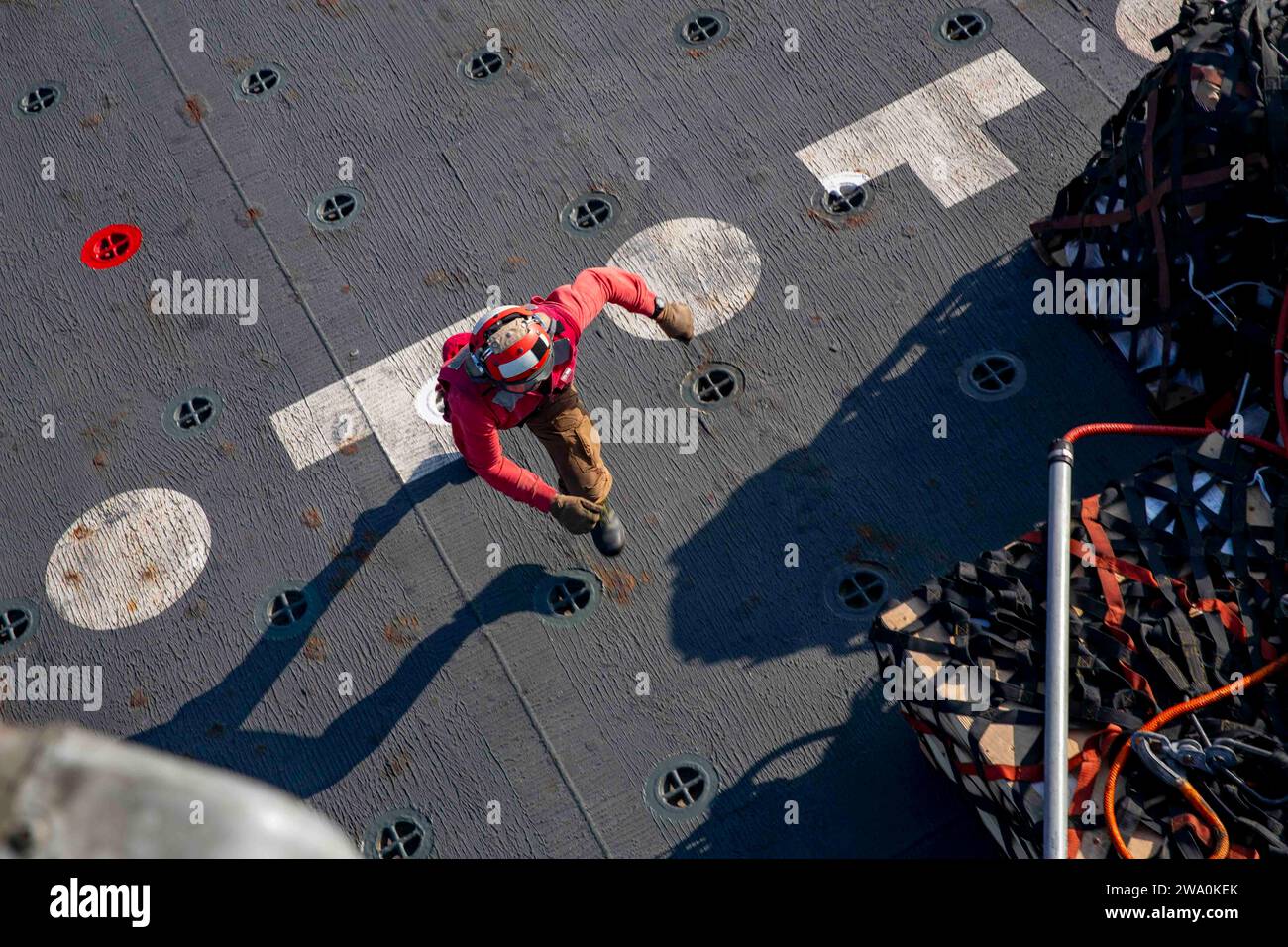Un marinaio a bordo dell'incrociatore missilistico guidato classe Ticonderoga USS Philippine Sea (CG 58) corre durante un rifornimento verticale 13 novembre 2023. L'Eisenhower Carrier Strike Group è schierato nell'area operativa della 5th Fleet degli Stati Uniti per sostenere la sicurezza marittima e la stabilità nella regione del Medio Oriente. (Foto della Marina degli Stati Uniti di Mass Communication Specialist 2nd Class Merissa Daley) Foto Stock