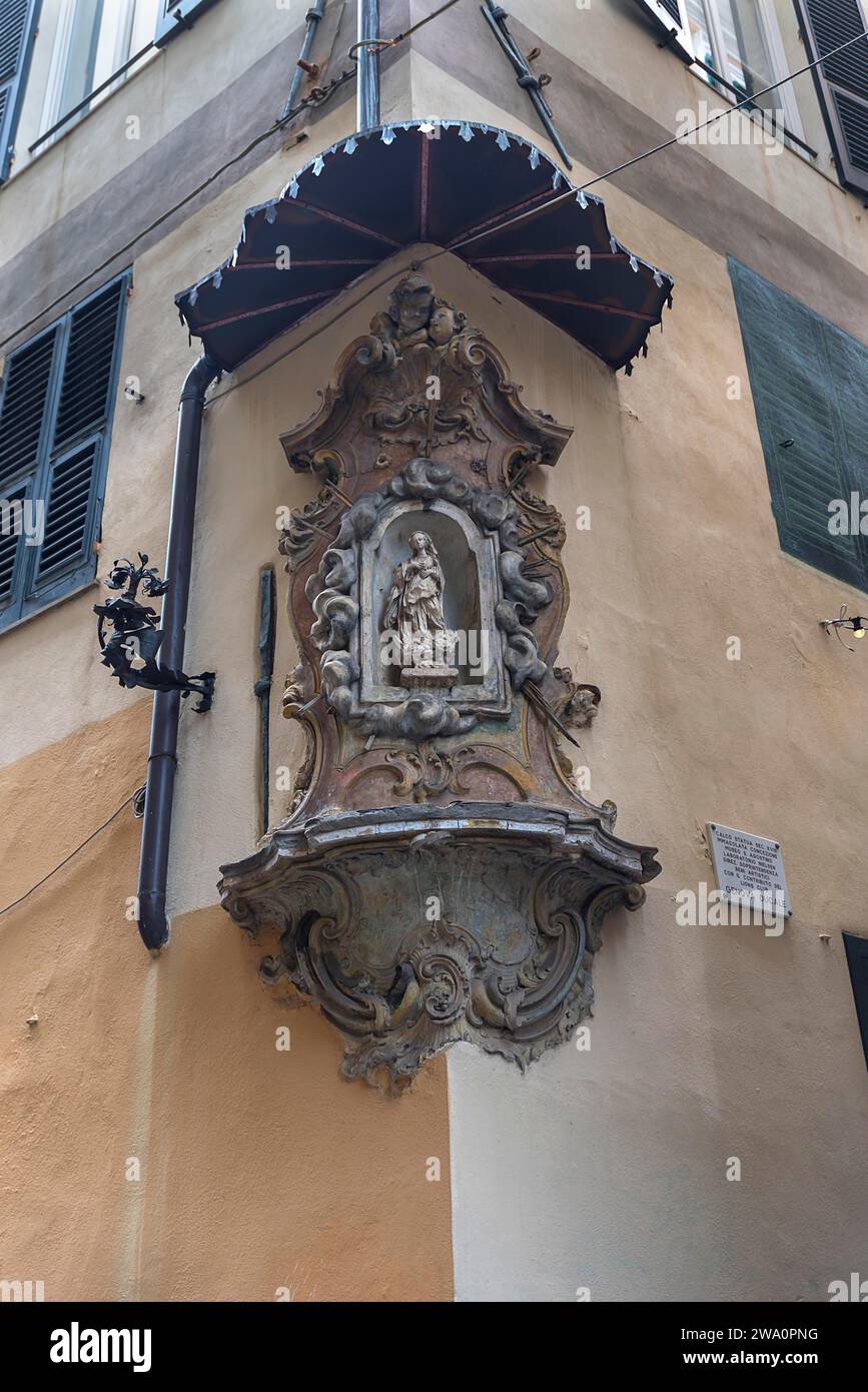 Scultura della Vergine Maria sotto un baldacchino su una casa d'angolo nel centro storico di Genova, Italia, Europa Foto Stock