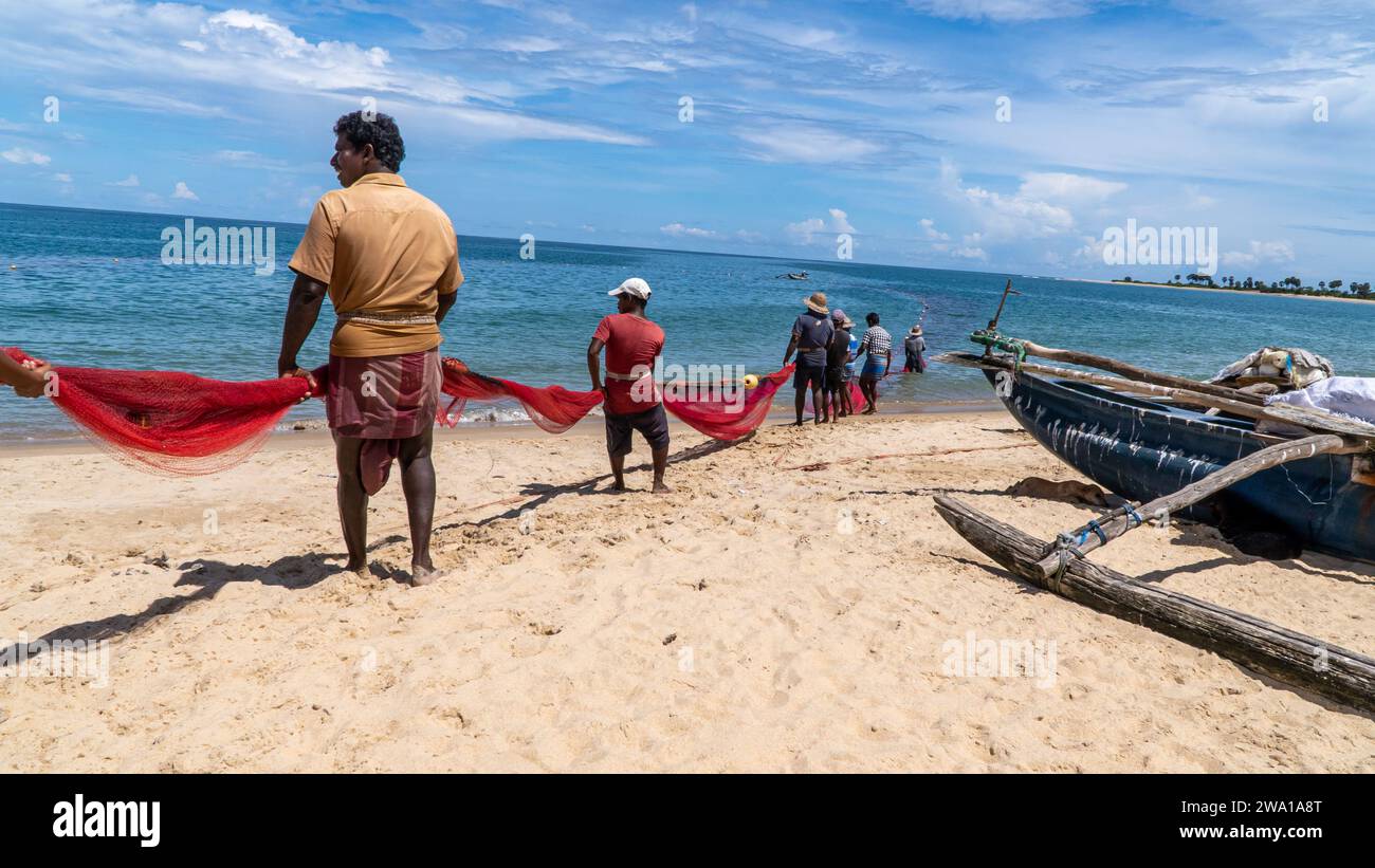 Sforzo di squadra: Rete di pesca di gruppo a Kalkudah Beach, Sri Lanka orientale Foto Stock
