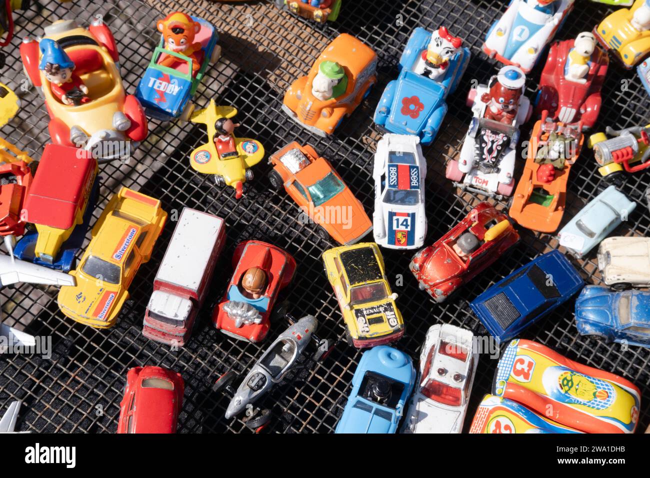 Tutti i tipi di macchinine giocattolo in metallo vecchio e plastica a buon mercato in un mercato delle pulci di Maastricht, visto dall'alto Foto Stock