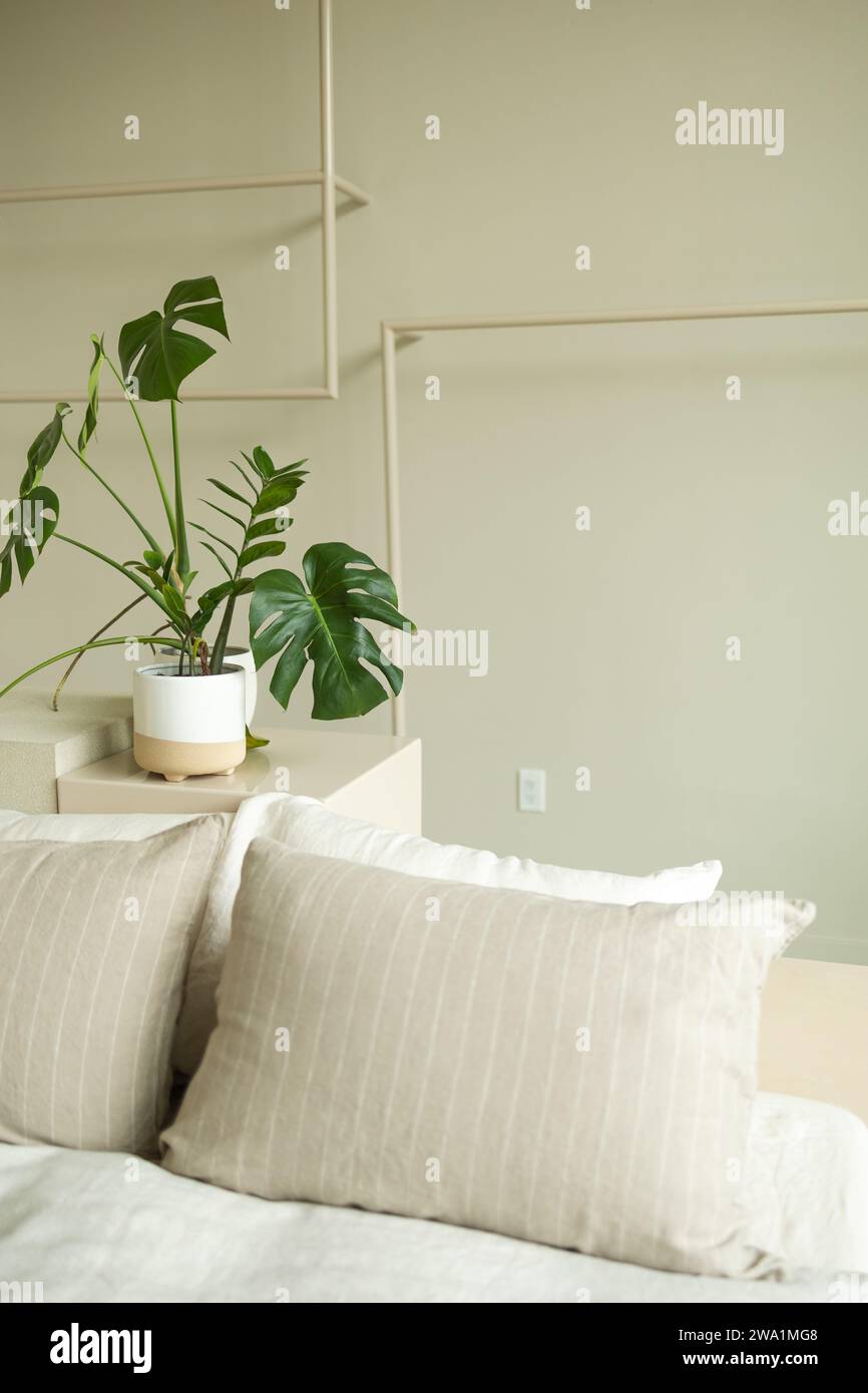 L'estetica della camera da letto accanto alla pianta in vaso crea uno spazio di tranqil Foto Stock
