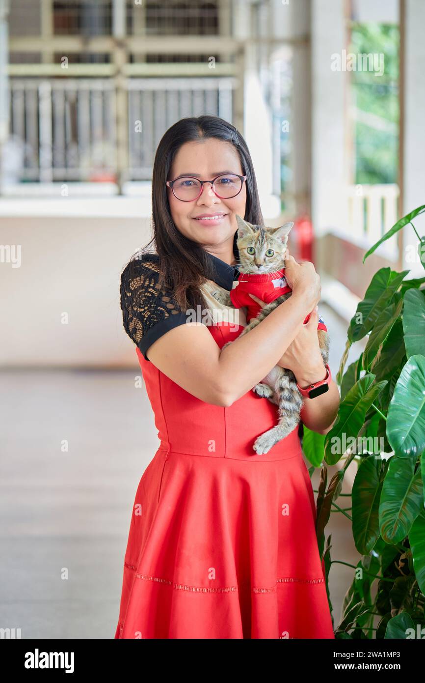 Ritratto di una donna asiatica che tiene il gatto in braccio Foto Stock