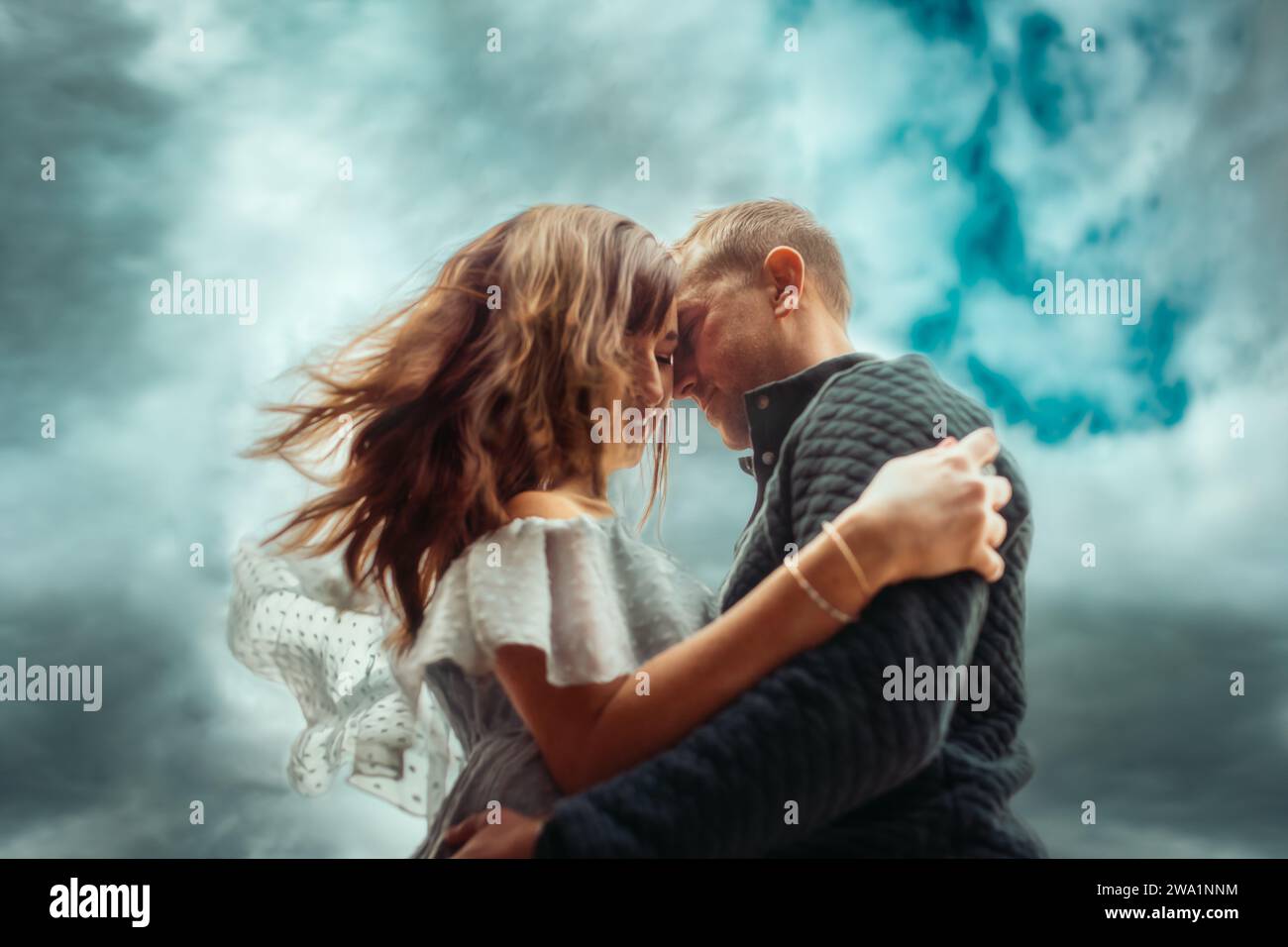 Coppia che abbraccia il cielo blu dietro di loro Foto Stock