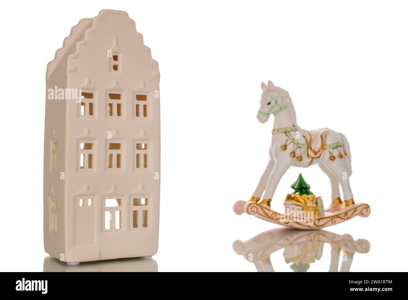 Una casa in argilla con cavallo in ceramica, giocattolo di Natale, macro, isolata su sfondo bianco. Foto Stock