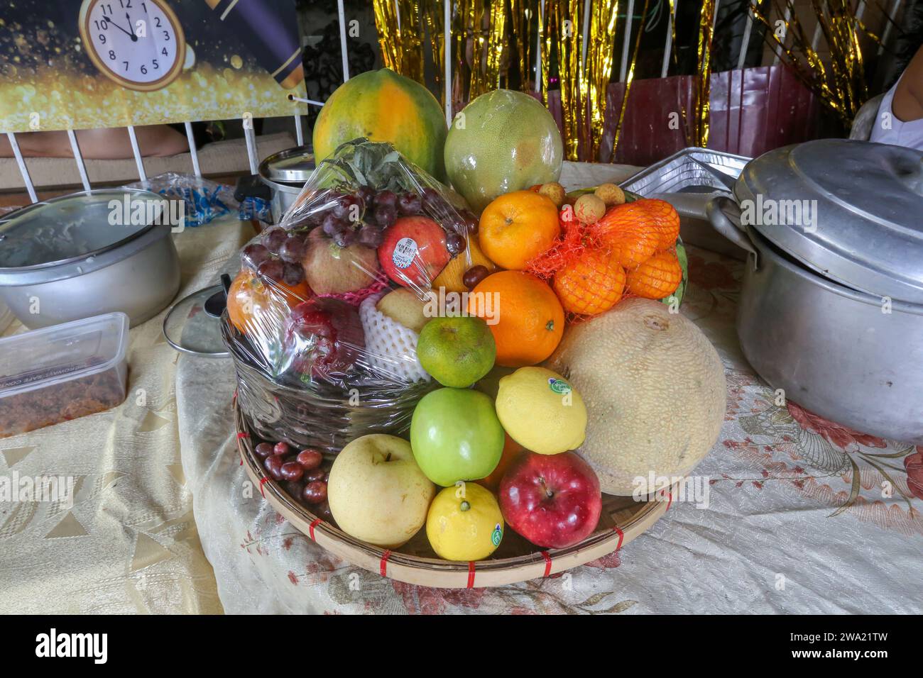 San Antonio, Filippine. 1 gennaio 2024: Le celebrazioni del Capodanno filippino sono piene di superstizioni e credenze popolari, un patrimonio ricco di influenze cinesi, spagnole, cattoliche e pagane. Tra indossare le caramelle rosse, saltare a mezzanotte, mangiare riso appiccicoso o fare forti rumori per scacciare gli spiriti maligni, una tradizione osservata dalla maggior parte dei filippini riguarda tutto ciò che è circolare in quanto simboleggia monete/denaro. Almeno 12 frutti rotondi devono essere presenti sul tavolo Media Noche. Una pratica costosa con l'aumento dei prezzi della frutta durante il periodo natalizio. Crediti: Kevin Izorce/Alamy Live News Foto Stock
