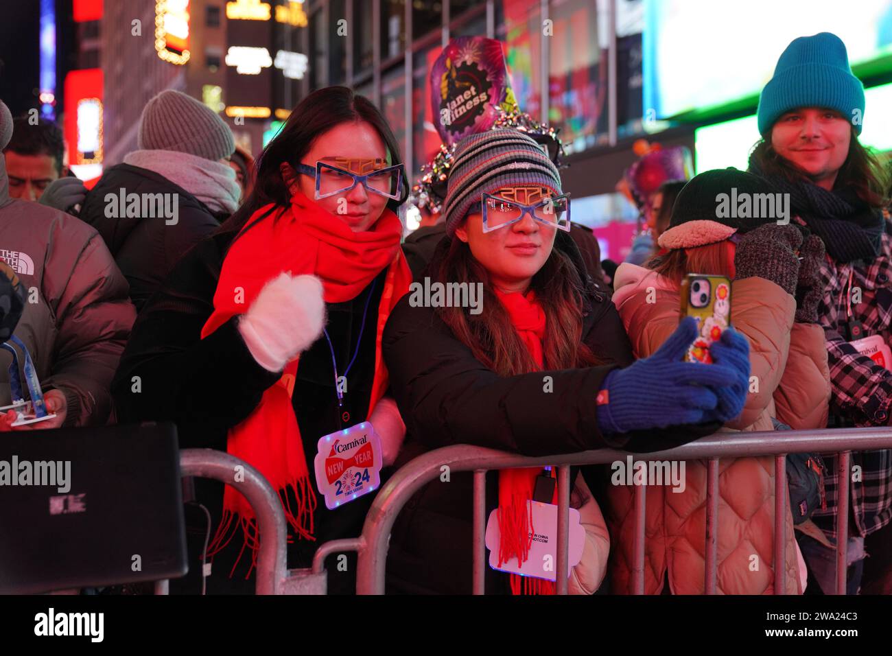 New York, USA. 31 dicembre 2023. La gente selfie mentre aspetta il conto alla rovescia fino all'anno 2024. La celebrazione del Capodanno 2024 di Times Square a New York City segna un ritorno monumentale dopo la pandemia di COVID-19, attirando migliaia di persone entusiaste a partecipare all'iconico conto alla rovescia e ad accogliere il nuovo anno. Come la tradizione vuole, la scintillante caduta della palla cattura la folla, segnalando il passaggio al 2024. Credito: SOPA Images Limited/Alamy Live News Foto Stock