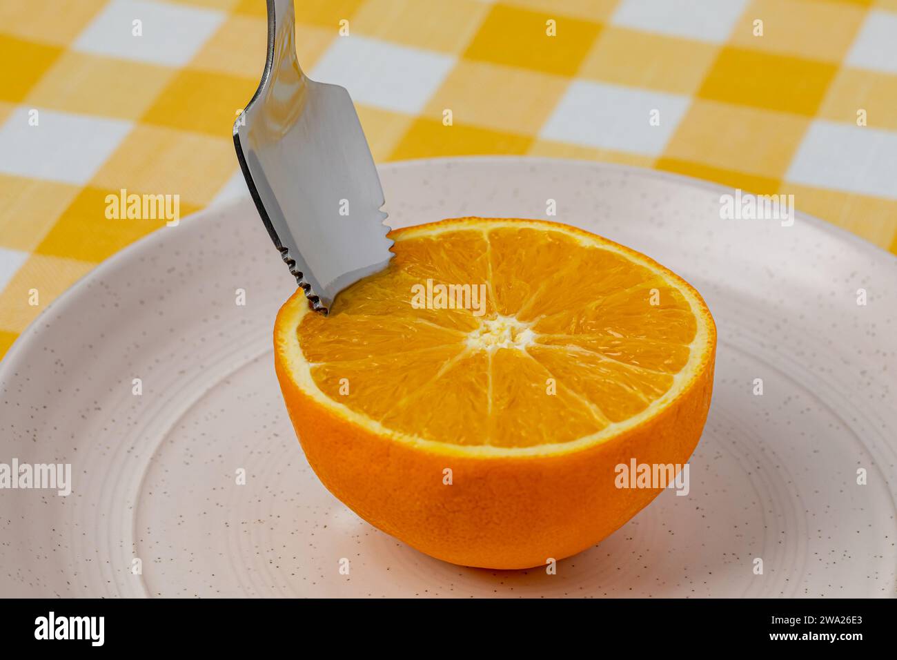 Arancia a fette su piatto con cucchiaio seghettato. Frutta biologica, dieta sana e concetto nutrizionale. Foto Stock