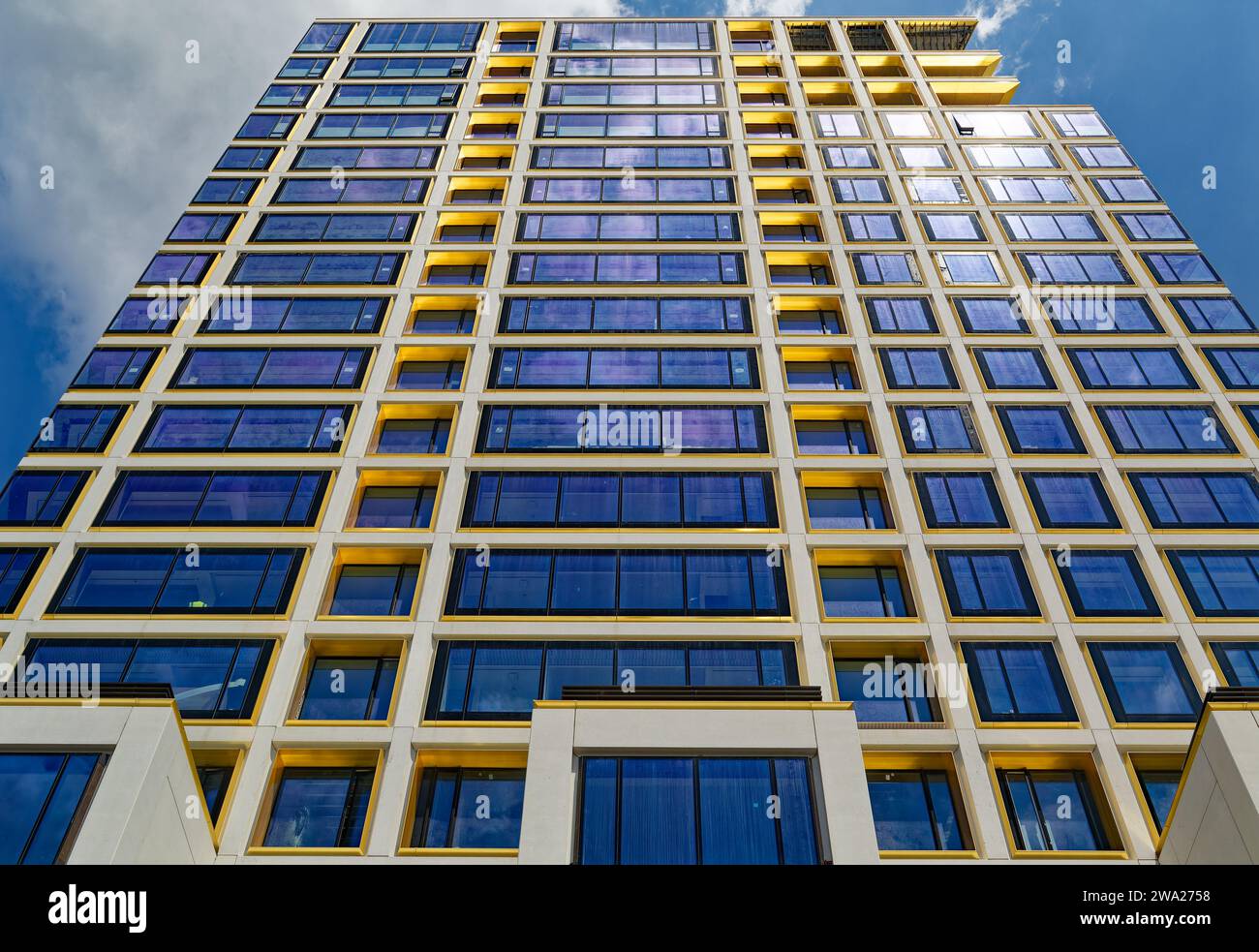 Cielo blu riflesso, finiture in bronzo giallo e calcestruzzo bianco scuro creano motivi impressionanti al 551 West 21st Street, un condominio residenziale. Foto Stock