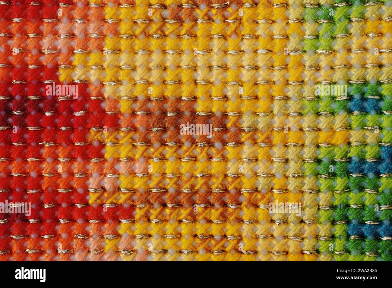 Uno scatto ravvicinato di uno sfondo con cuciture incrociate con motivo arcobaleno sfumato. Foto Stock