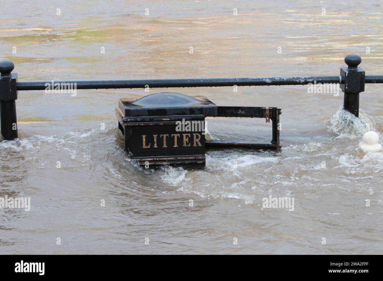 Il fiume Severn in piena che copre ringhiere e un cestino di rifiuti sulle sue rive. Bewdley. Worcestershire. Regno Unito, dicembre 2023 Foto Stock