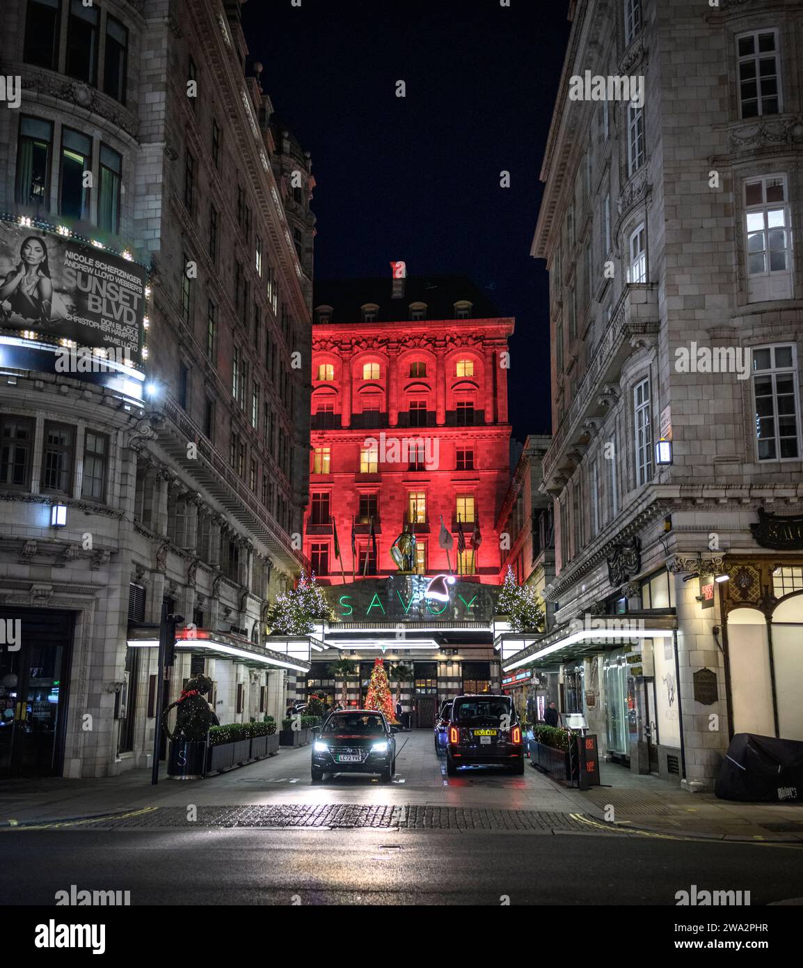 Il famoso hotel Savoy è illuminato a luci rosse durante il periodo natalizio a Londra, Inghilterra, Regno Unito Foto Stock
