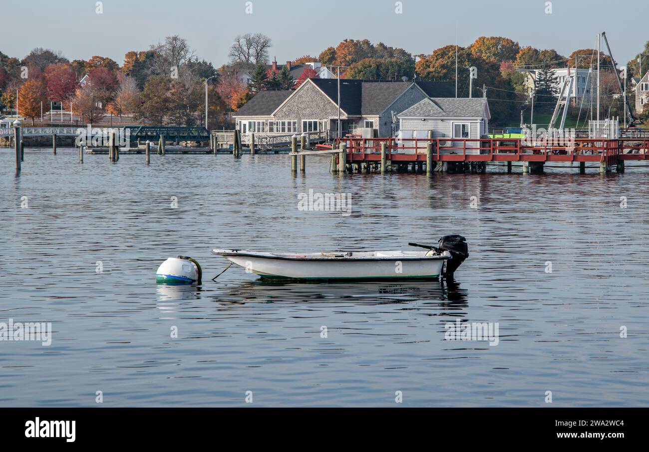 Piccola barca a bordo di una boa di ormeggio: Una piccola barca da pesca è ancorata a una palla di ormeggio in un porto del New England. Foto Stock