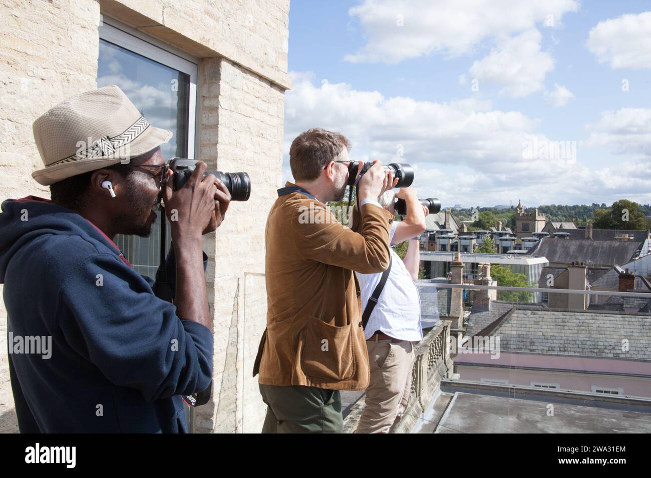 Fotografi in fila che fotografano la città di Oxford dal tetto della biblioteca Weston nel Regno Unito Foto Stock