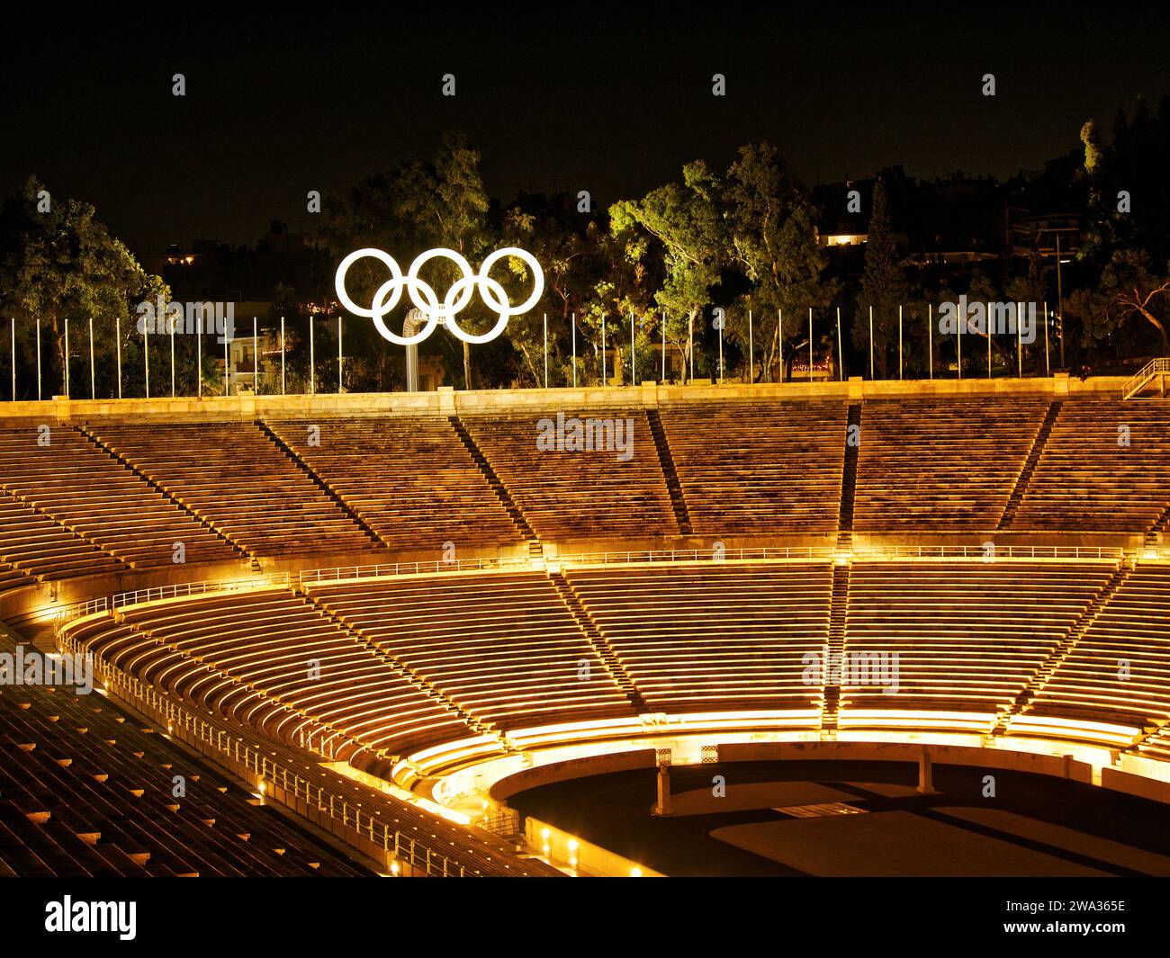 Vista ad alto angolo dello Stadio Panatenaico illuminato di Atene con insegna delle Olimpiadi durante una visita notturna. Grecia Foto Stock