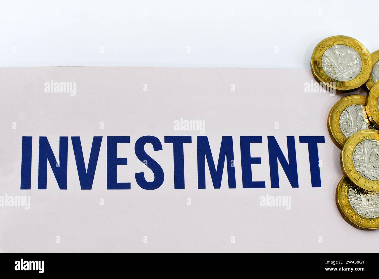 Monete inglesi da una sterlina insieme a un documento di investimento. Niente persone. Foto Stock