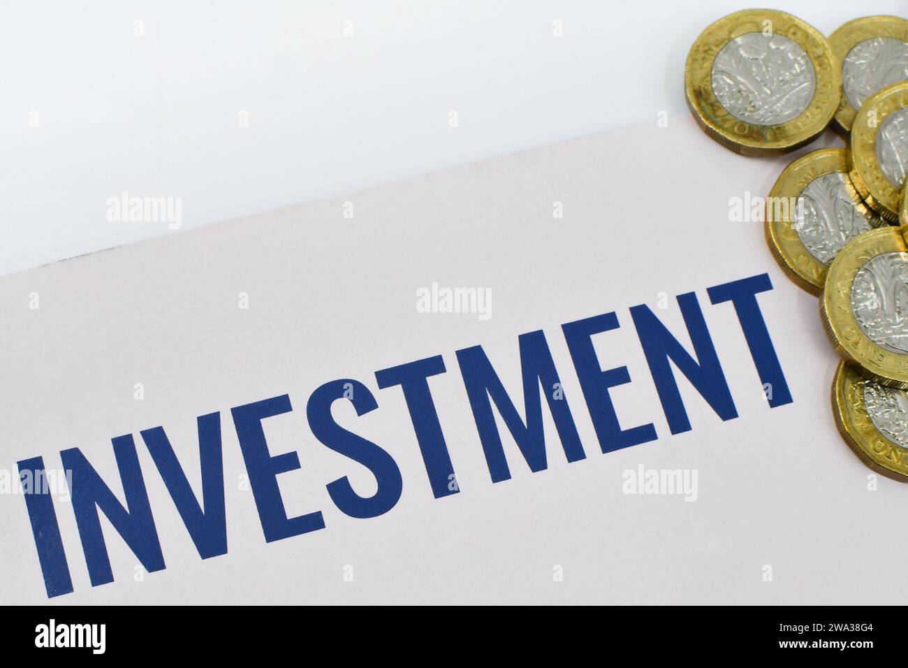 Monete inglesi da una sterlina insieme a un documento di investimento. Niente persone. Foto Stock