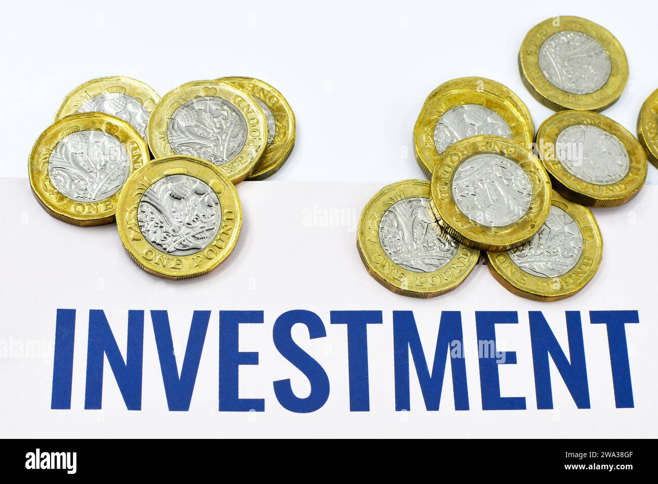 Monete inglesi da una sterlina insieme a un documento di investimento. Niente persone. Foto Stock