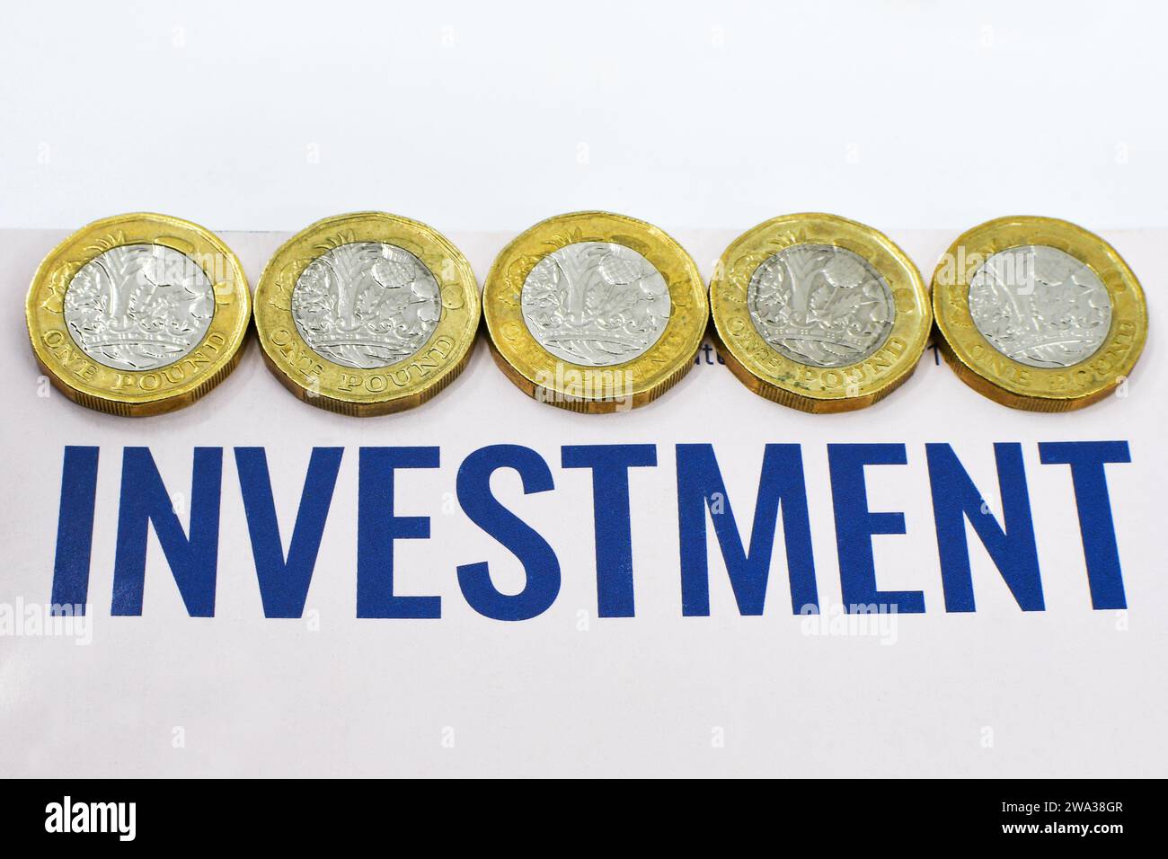 Monete inglesi da una sterlina insieme a un documento di investimento. Niente persone. Foto Stock