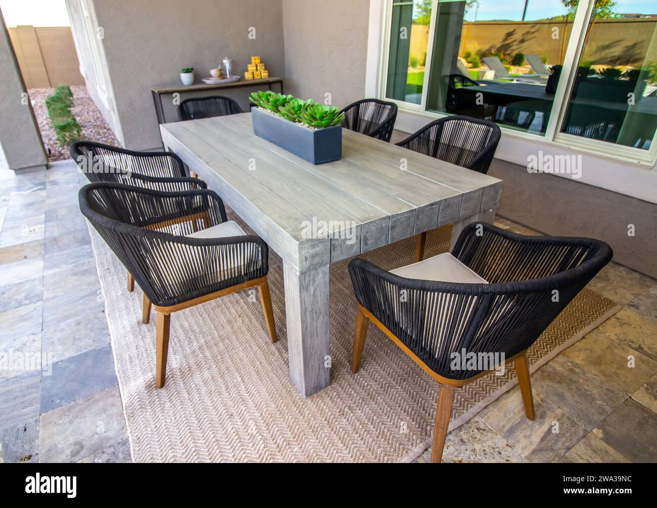 Tavolo in legno e sedie in rattan sul patio posteriore Foto Stock