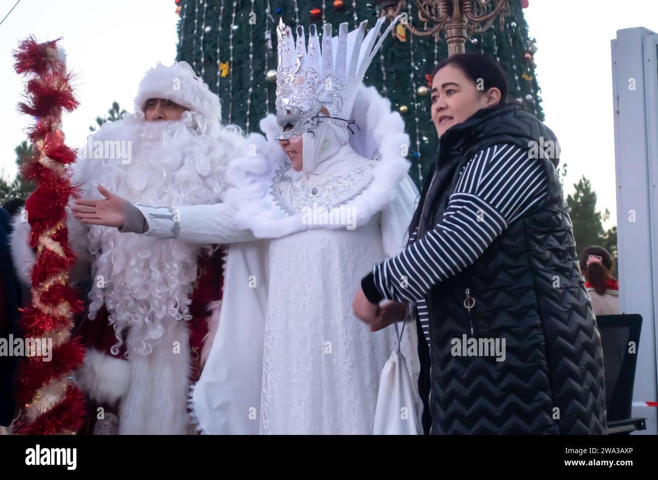 Festa di Capodanno piazza Kuk Saroy Samarcanda Uzbekistan. Padre Frost - Babbo Natale e Snegurochka, signora della neve, costumi che scattano foto Foto Stock
