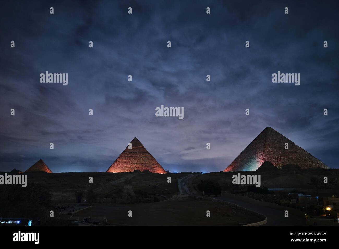 Giza, Egitto - 24 dicembre 2023: Le piramidi e la Sfinge nelle luci notturne Foto Stock