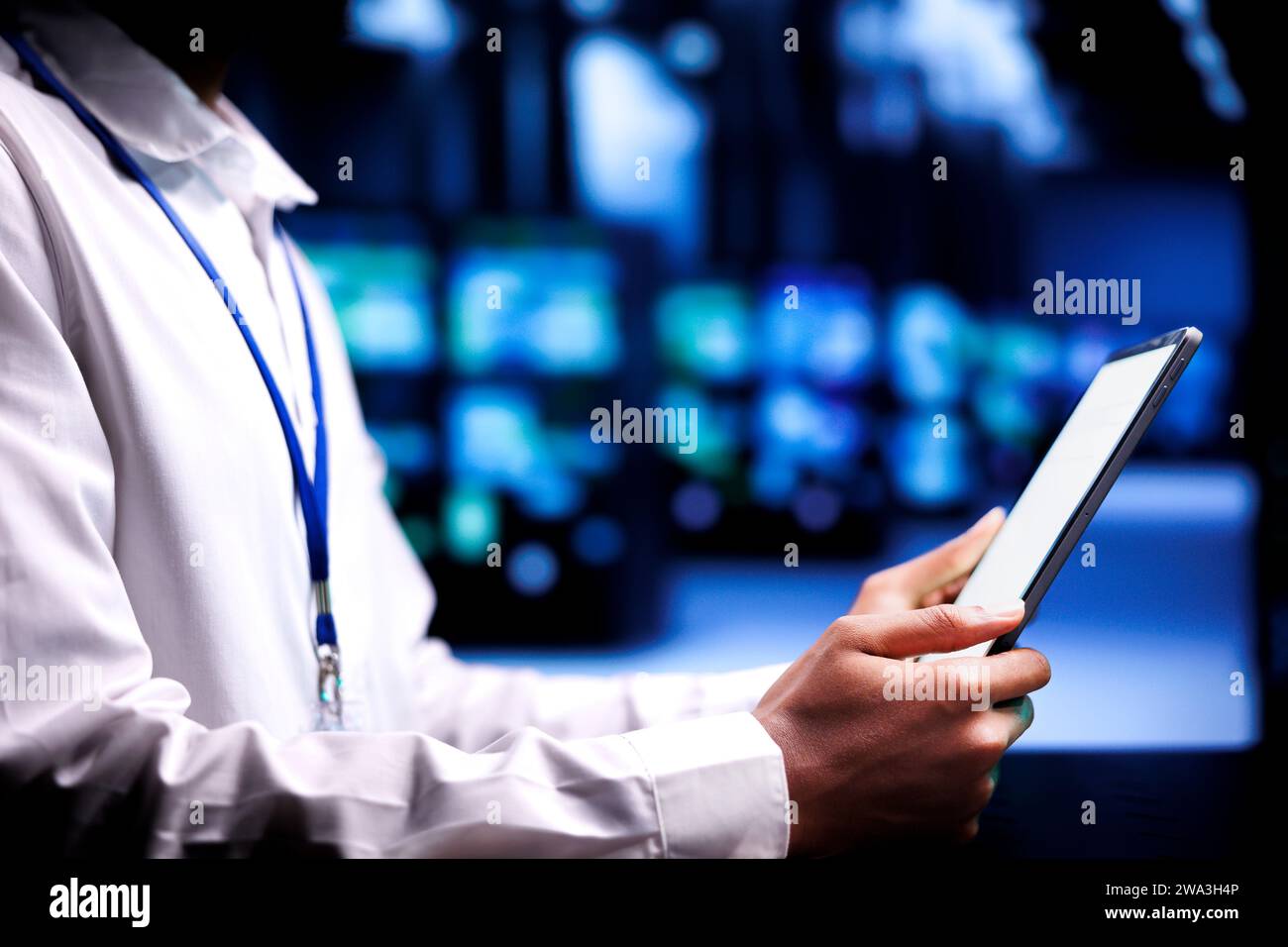 Tecnici competenti che risolvono i problemi relativi alle prestazioni nella server farm. Sviluppatore che utilizza un tablet mock-up per identificare i problemi operativi che causano il rallentamento dei rack del data center Foto Stock