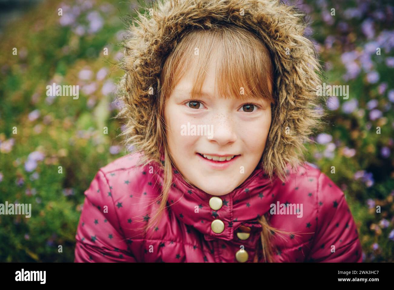 Immagine ravvicinata di una graziosa bambina che indossa una calda giacca invernale con cappuccio Foto Stock