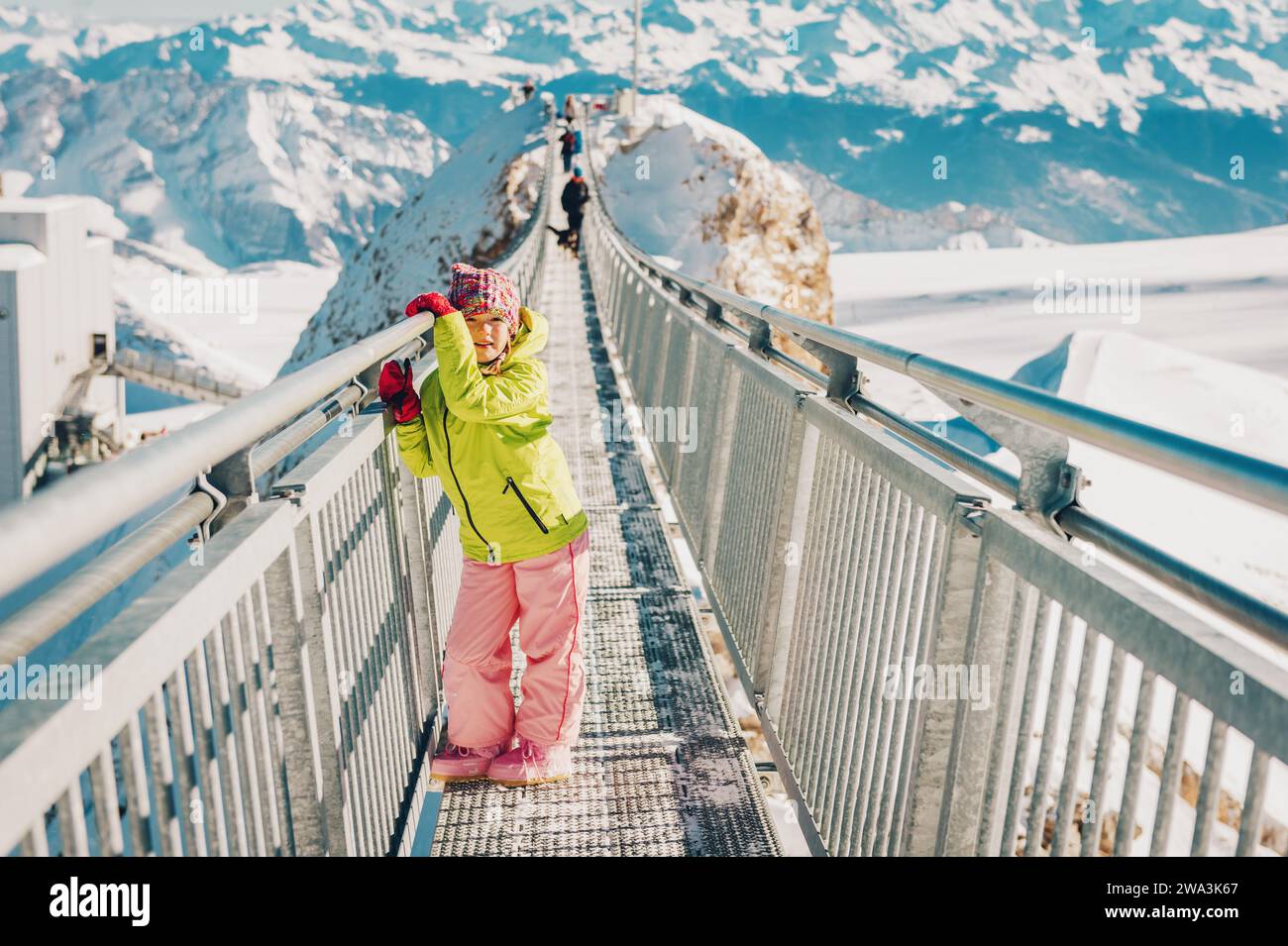 Bambina che gioca con la neve sulla cima della montagna, vacanze invernali con bambini, attività per famiglie sulle Alpi. Immagine scattata nel ghiacciaio 3000, cantone Foto Stock