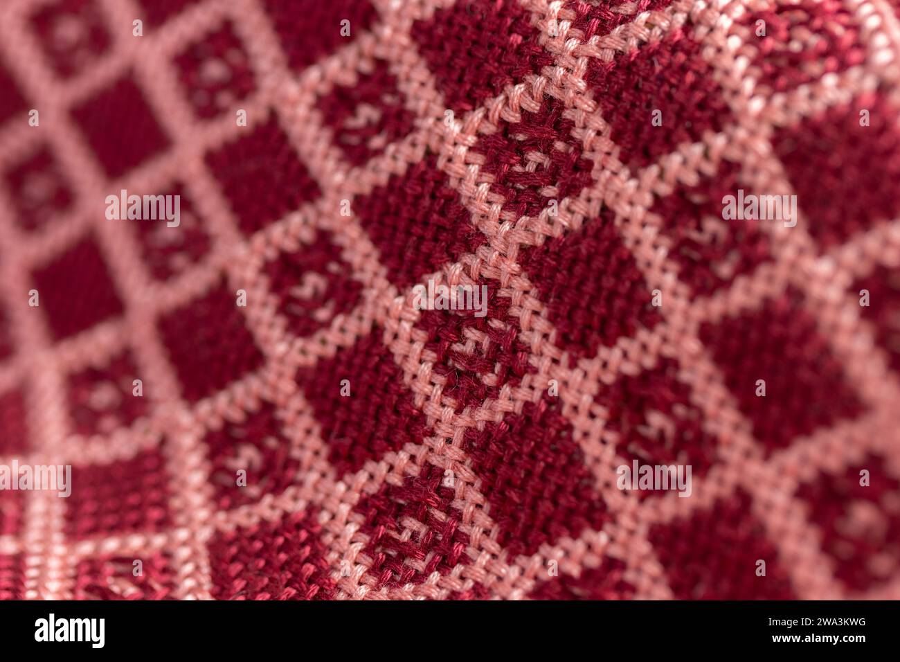 doppio panno in tessuto drappeggiato geometrico rosso e rosa, motivo a griglia diamantato, foto di dettaglio macro ravvicinato con profondità di campo ridotta Foto Stock