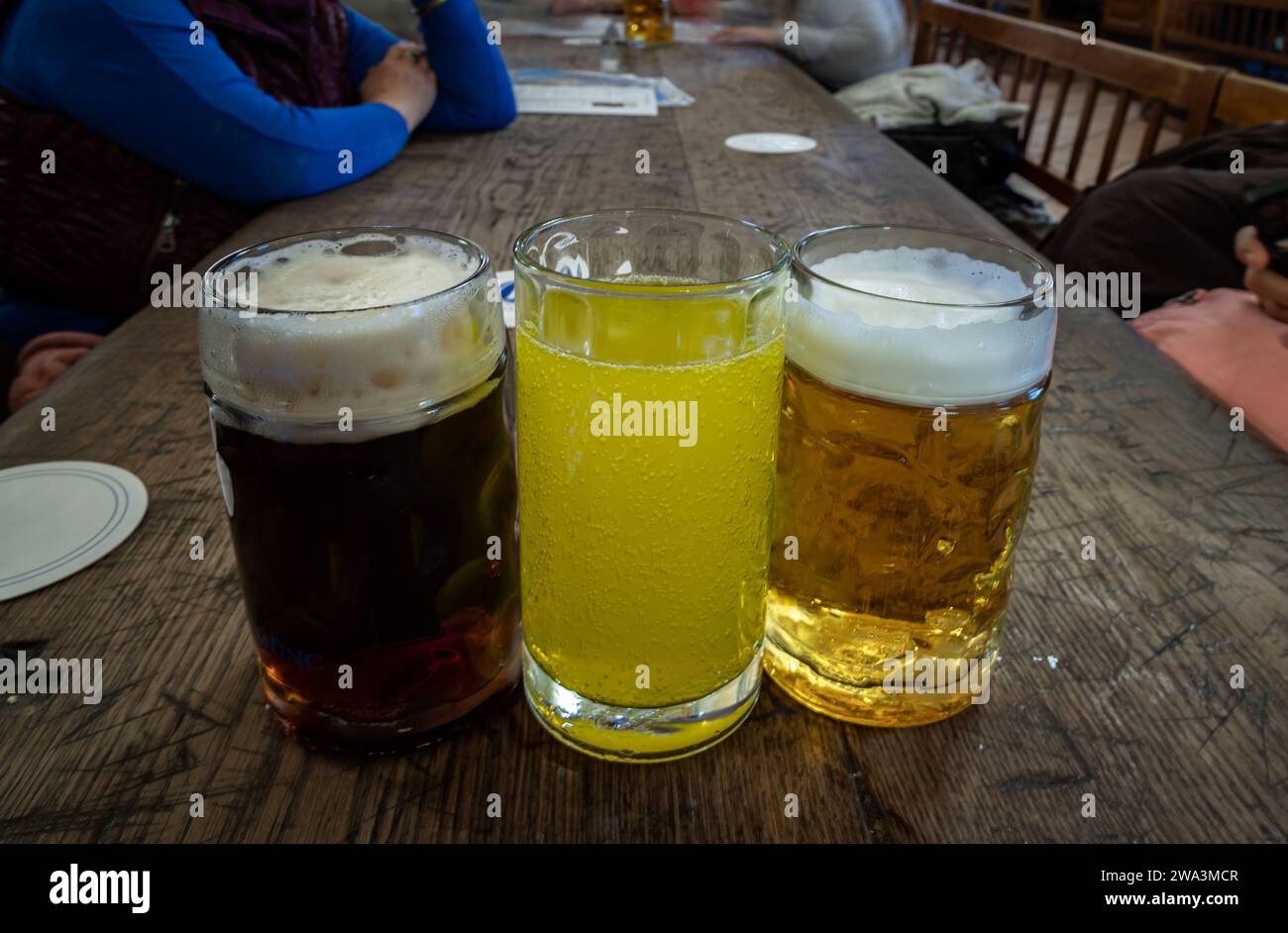 Tre bicchieri di diversi tipi di birra fredda e gustosa sono in fila su un tavolo di legno in un ristorante. Tavolo per la compagnia degli amici, spazio per testo, Sele Foto Stock